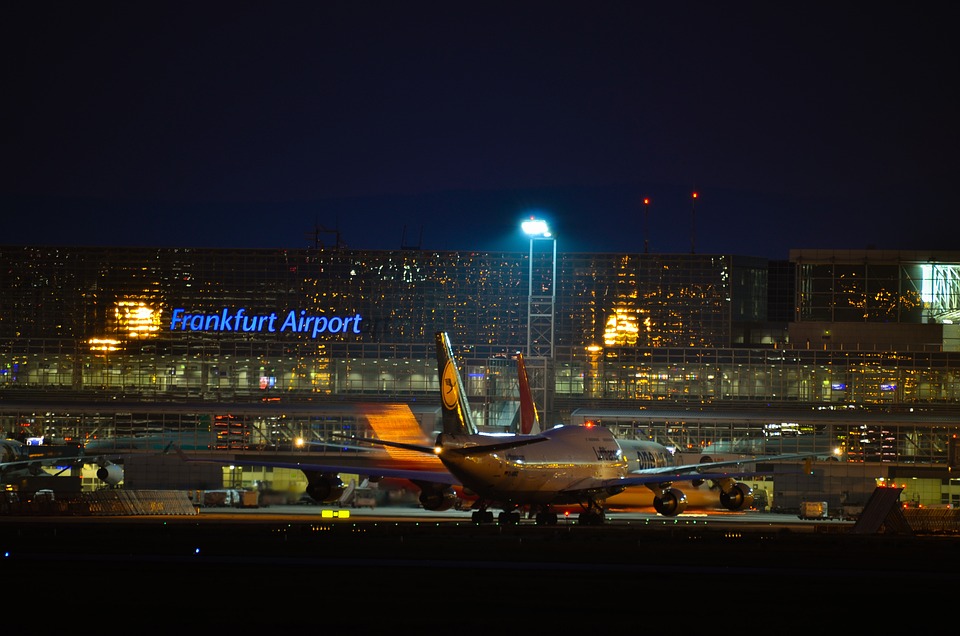 L'aéroport de Francfort, de nuit, avec un avion au premier plan.