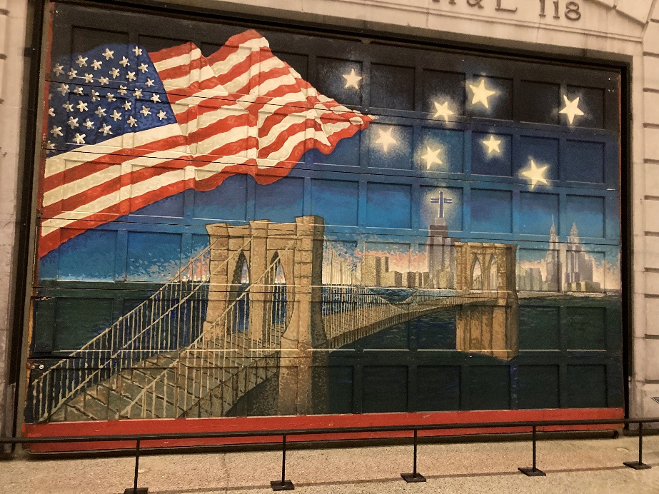 Fresque sur la porte de la caserne des pompiers de New York, représentant le Brooklin Bridge, le drapeau américain et la ville de New York surmontée d'étoiles.